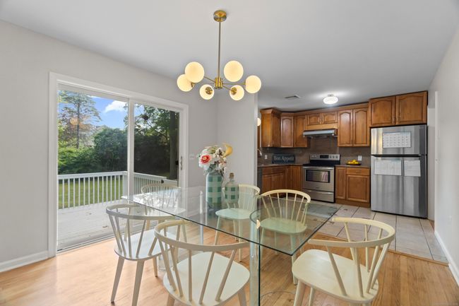 Sunny dining room opens up into the kitchen and has sliders out to the spacious deck | Image 6