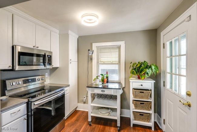 Kitchen featuring dark wood finished floors, a wealth of natural light, and stainless steel appliances | Image 13