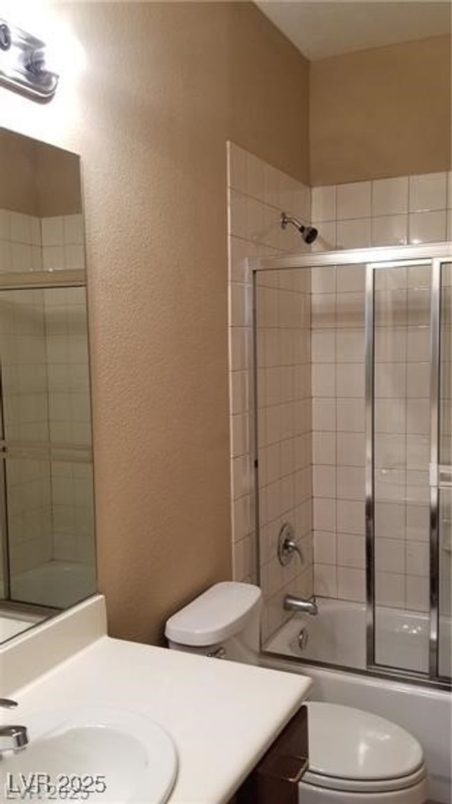Full bathroom featuring vanity, enclosed tub / shower combo, and a textured wall | Image 30