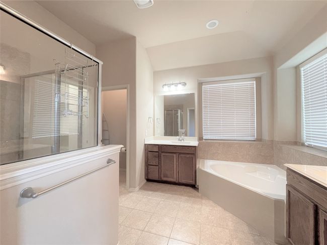 Full bath with vanity, a shower stall, a bath, and tile patterned floors | Image 12