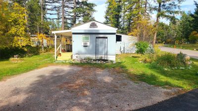 View of outdoor structure with cooling unit and a yard | Image 3