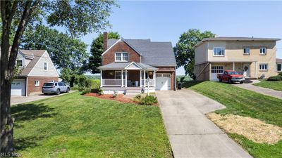 View of front facade featuring a front lawn, a garage, and a porch | Image 2