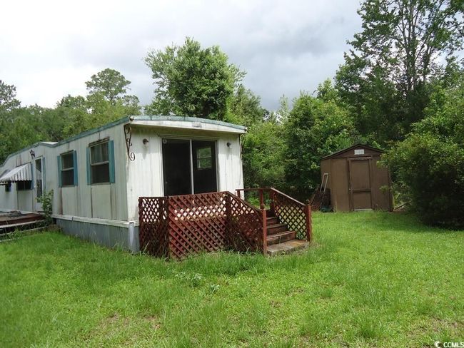 View of home's exterior with a storage shed and a yard | Image 7