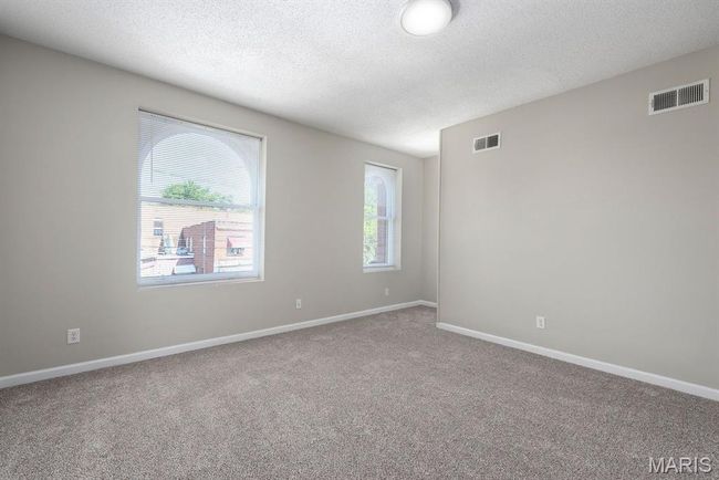 Empty room with a textured ceiling and carpet flooring | Image 11