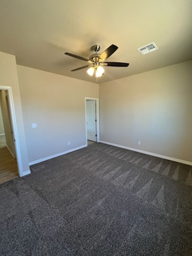 Spare room with dark carpet, baseboards, and ceiling fan | Image 20
