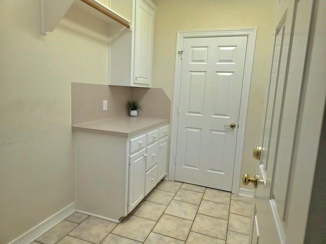 Spacious laundry room featuring ample cabinetry and countertop space for efficient organization. | Image 42