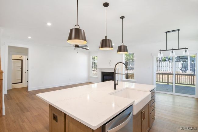 Photo represents the plan, not the actual home. Design selections may vary. A spacious kitchen with an island and pantry open to an adjoining dining area and the family room. | Image 10