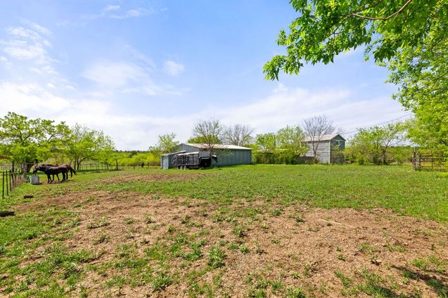 View of yard featuring an outdoor structure, an outbuilding, fence, and a rural view | Image 26