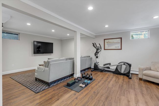 Workout room featuring ornamental molding, wood finished floors, recessed lighting, and baseboard heating | Image 11