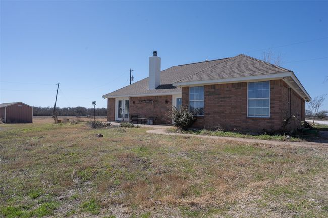 Back of house with a chimney, french doors, brick siding, and roof with shingles | Image 25