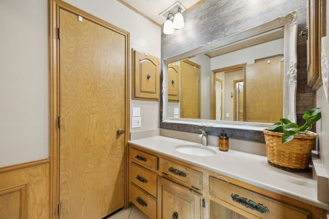 Second Vanity in Primary Bathroom with Wood-paneled Accent Wall | Image 26