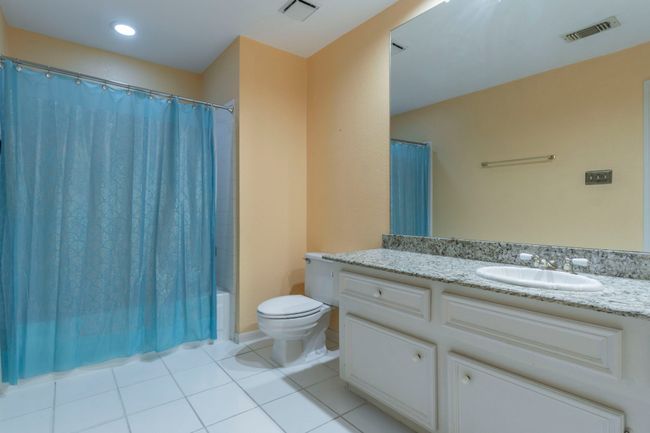 Bathroom with vanity, toilet, tile patterned flooring, and shower / bath combo with shower curtain | Image 24