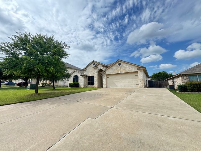 View of front facade featuring stone siding, driveway, and a garage | Image 30