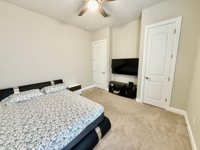 Bedroom featuring baseboards, light colored carpet, and a ceiling fan | Image 20