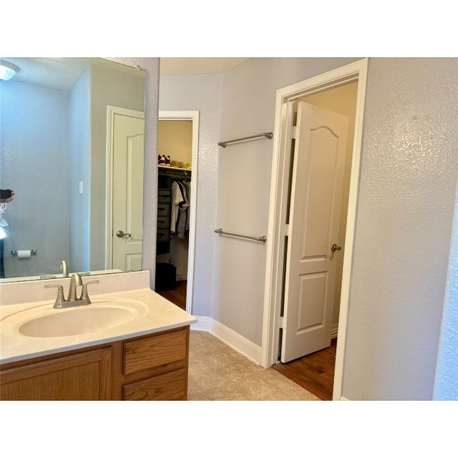 Large primary bathroom with two walk-in closets, two separate vanities, large garden tub and shower combo, toilet area | Image 26