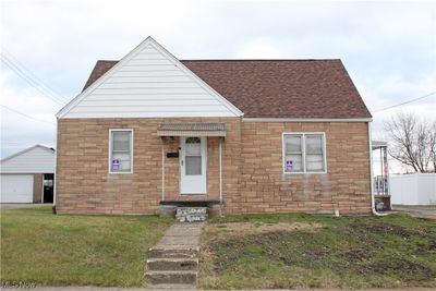 View of front of property with a garage and a front lawn | Image 1