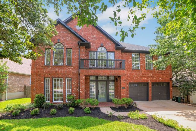 Colonial home featuring concrete driveway, brick siding, a garage, and a front lawn | Image 36