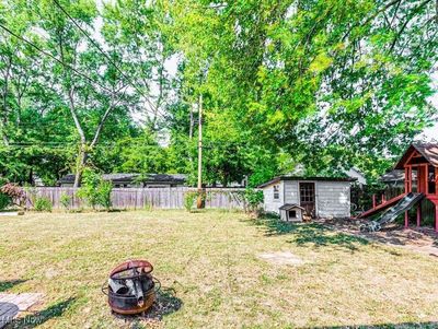 View of yard featuring a storage unit, a fire pit, and a playground | Image 3