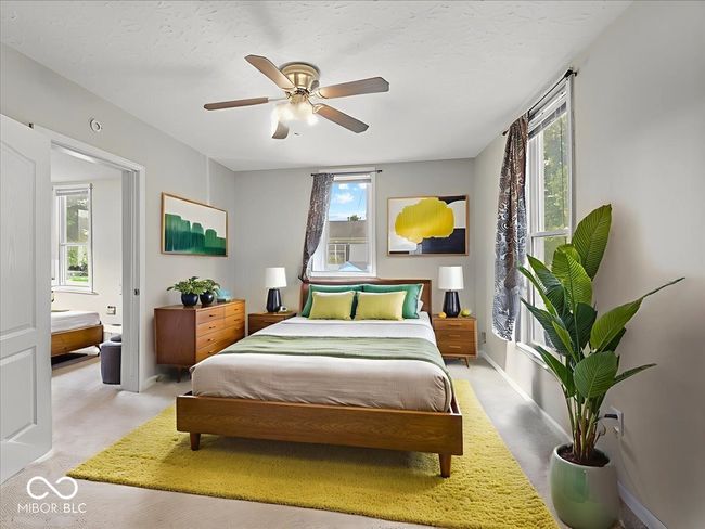 bedroom featuring multiple windows, a ceiling fan, light carpet, and a textured ceiling | Image 11