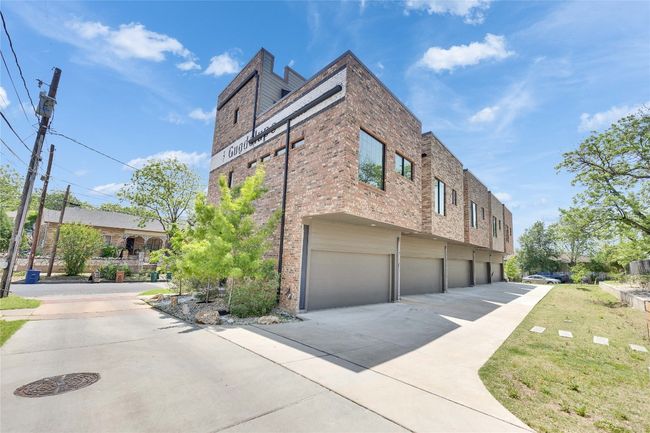 View of property exterior with a garage, driveway, and brick siding | Image 32