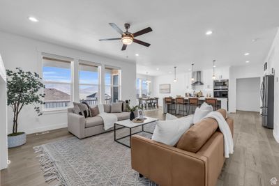 Living room featuring light hardwood / wood-style floors, a mountain view, and ceiling fan with notable chandelier | Image 3