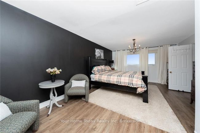 Bedroom featuring lofted ceiling, hardwood / wood-style flooring, and a notable chandelier | Image 25