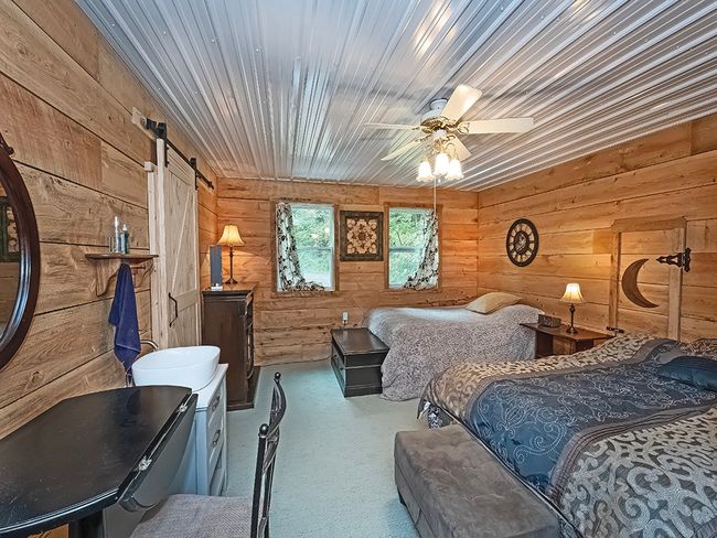 Bedroom over garage with commode behind sliding door. | Image 30