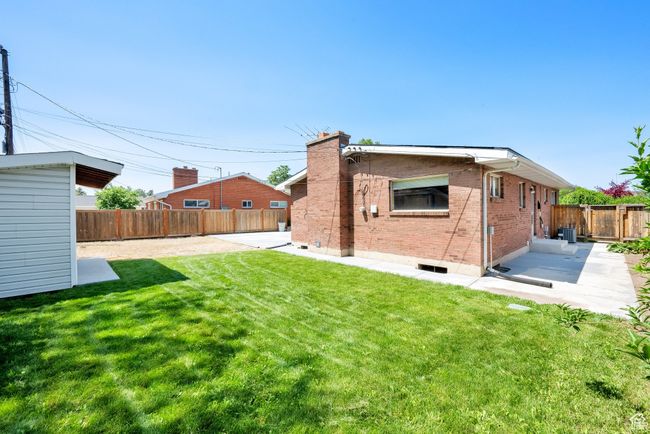 Rear view of property with a patio, brick siding, a chimney, and central air condition unit | Image 23