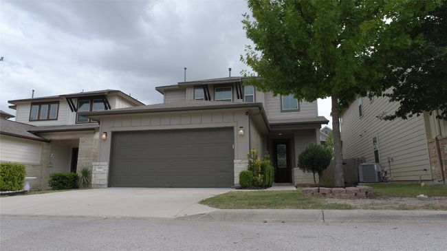 View of front of home with stone siding, a garage, and driveway | Image 37