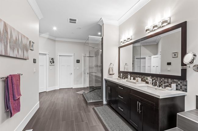 Bathroom with a sink, baseboards, ornamental molding, tasteful backsplash, and a stall shower | Image 19