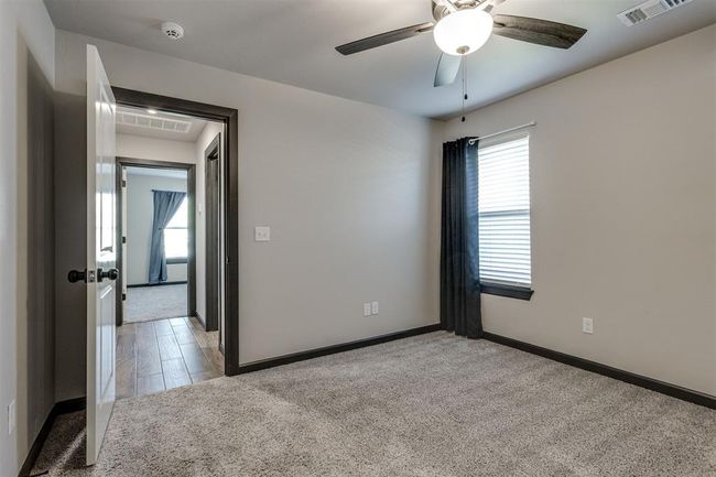 Carpeted empty room with baseboards, a ceiling fan, and visible vents | Image 15
