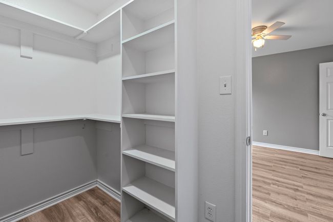 Primary Walk in closet featuring wood finished floors and ceiling fan | Image 16