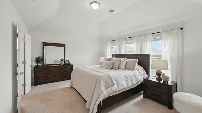 Bedroom with light colored carpet and lofted ceiling | Image 23