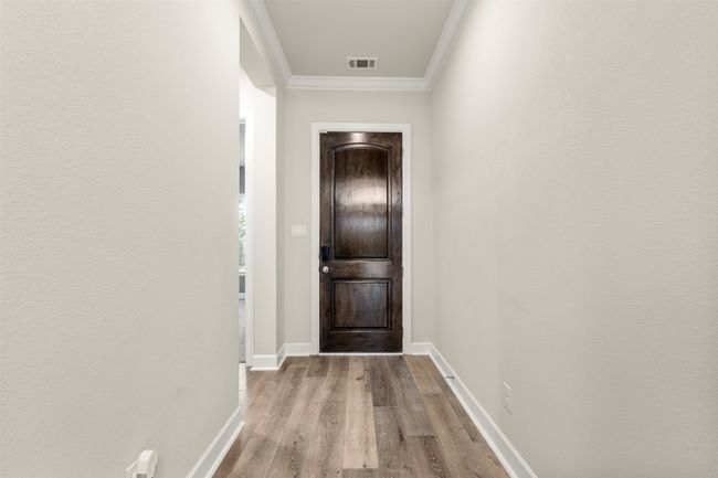 Entryway featuring ornamental molding, wood finished floors, and baseboards | Image 4