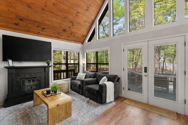 Living room with high vaulted ceiling, wood finished floors, french doors, a premium fireplace, and wooden ceiling | Image 19