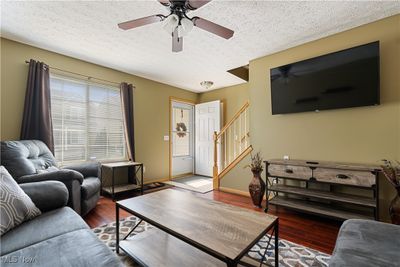 Living room with hardwood / wood-style flooring, ceiling fan, and a textured ceiling | Image 3