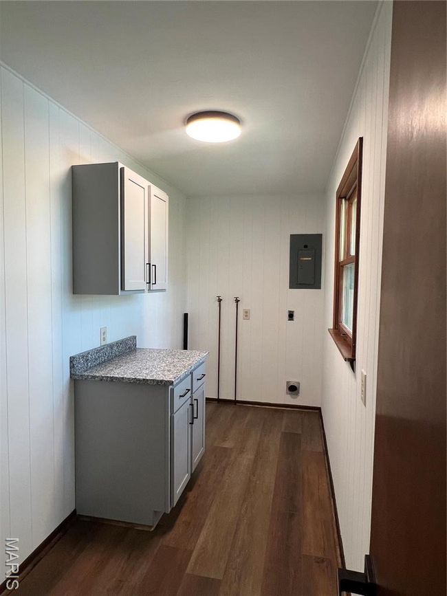 Washroom featuring electric panel, cabinet space, and dark wood-type flooring | Image 12