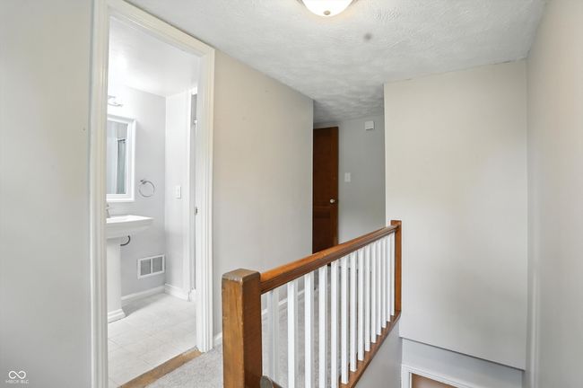 hall with an upstairs landing, a textured ceiling, and tile patterned floors | Image 31