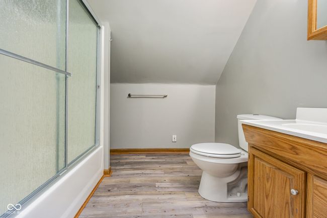 full bath featuring vanity, lofted ceiling, toilet, baseboards, and wood finished floors | Image 22