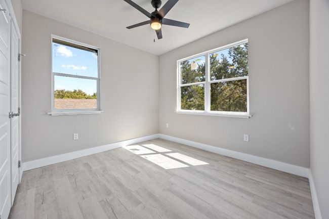 Unfurnished room featuring light wood-style floors, ceiling fan, and baseboards | Image 17