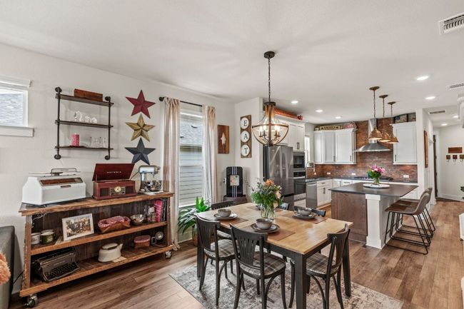 Dining space with plenty of natural light, visible vents, and dark wood-style flooring | Image 15