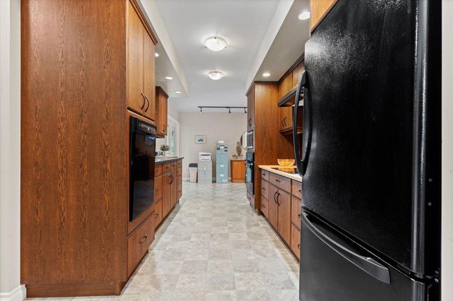 Kitchen featuring black appliances, brown cabinets, and recessed lighting | Image 26