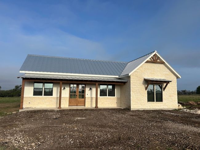 View of front of home featuring stone siding, french doors, metal roof, and a standing seam roof | Image 7