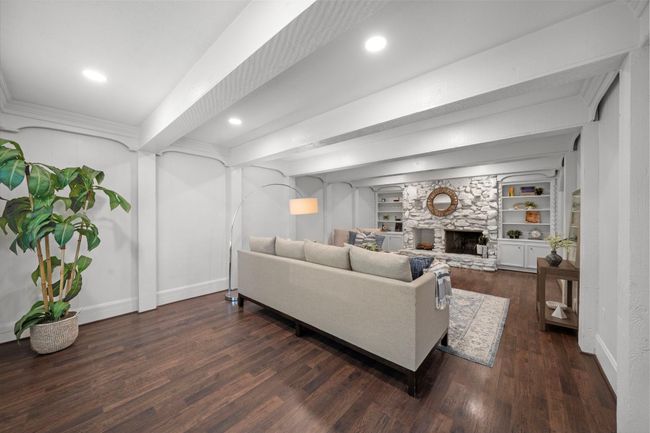 Wood burning fireplace is the accent of this space with built-in shelving and cabinetry. | Image 4