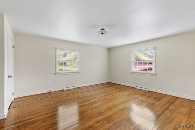Unfurnished room with a wealth of natural light, hardwood / wood-style flooring, baseboard heating, and baseboards | Image 21