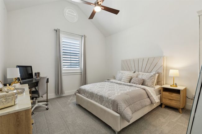 Bedroom with vaulted ceiling, light colored carpet, an office area, a ceiling fan, and baseboards | Image 28