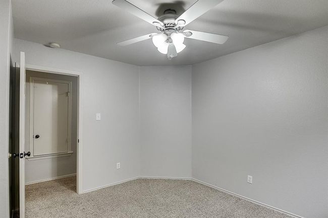 Carpeted empty room with a ceiling fan, baseboards, and a smoke detector | Image 17