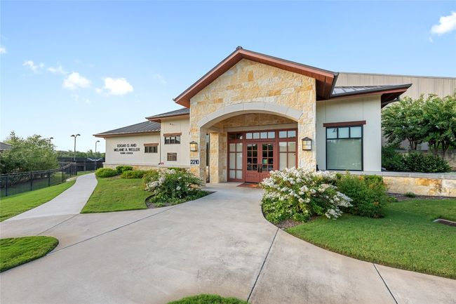View of front facade with a standing seam roof, stone siding, french doors, and a metal roof | Image 19