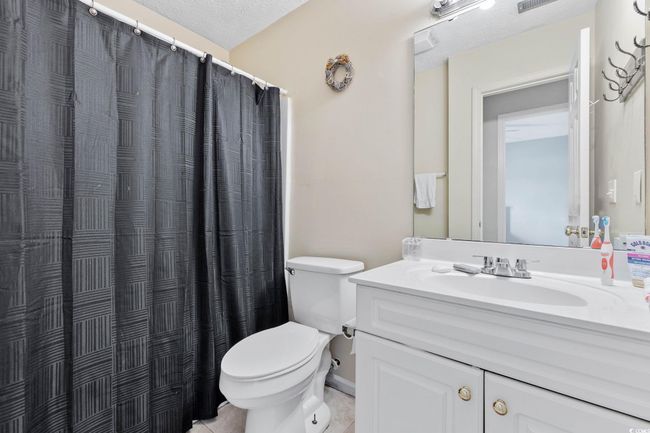 Full bathroom featuring vanity, tile patterned floors, and curtained shower | Image 9