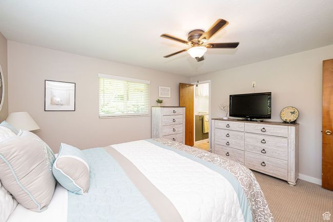 Bedroom with light colored carpet, baseboards, and ceiling fan | Image 33